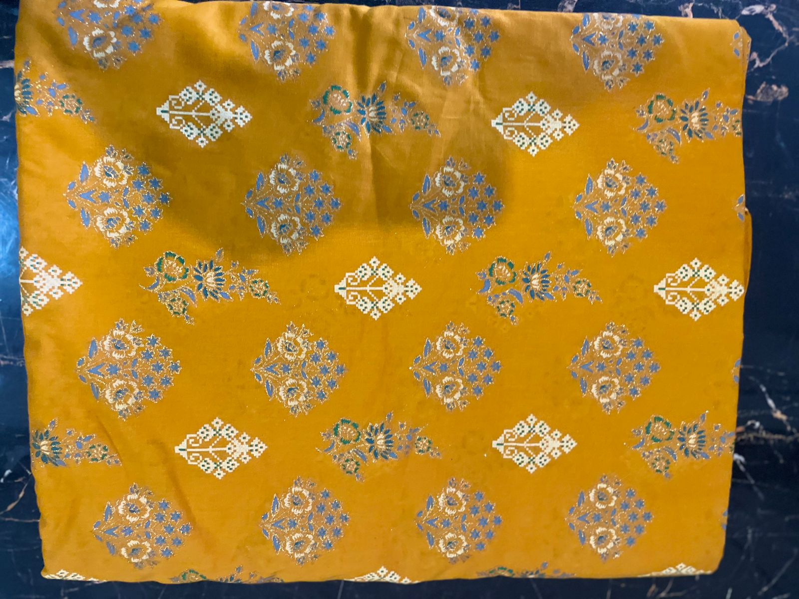 Yellow fabric with floral patterns on a dark blue background