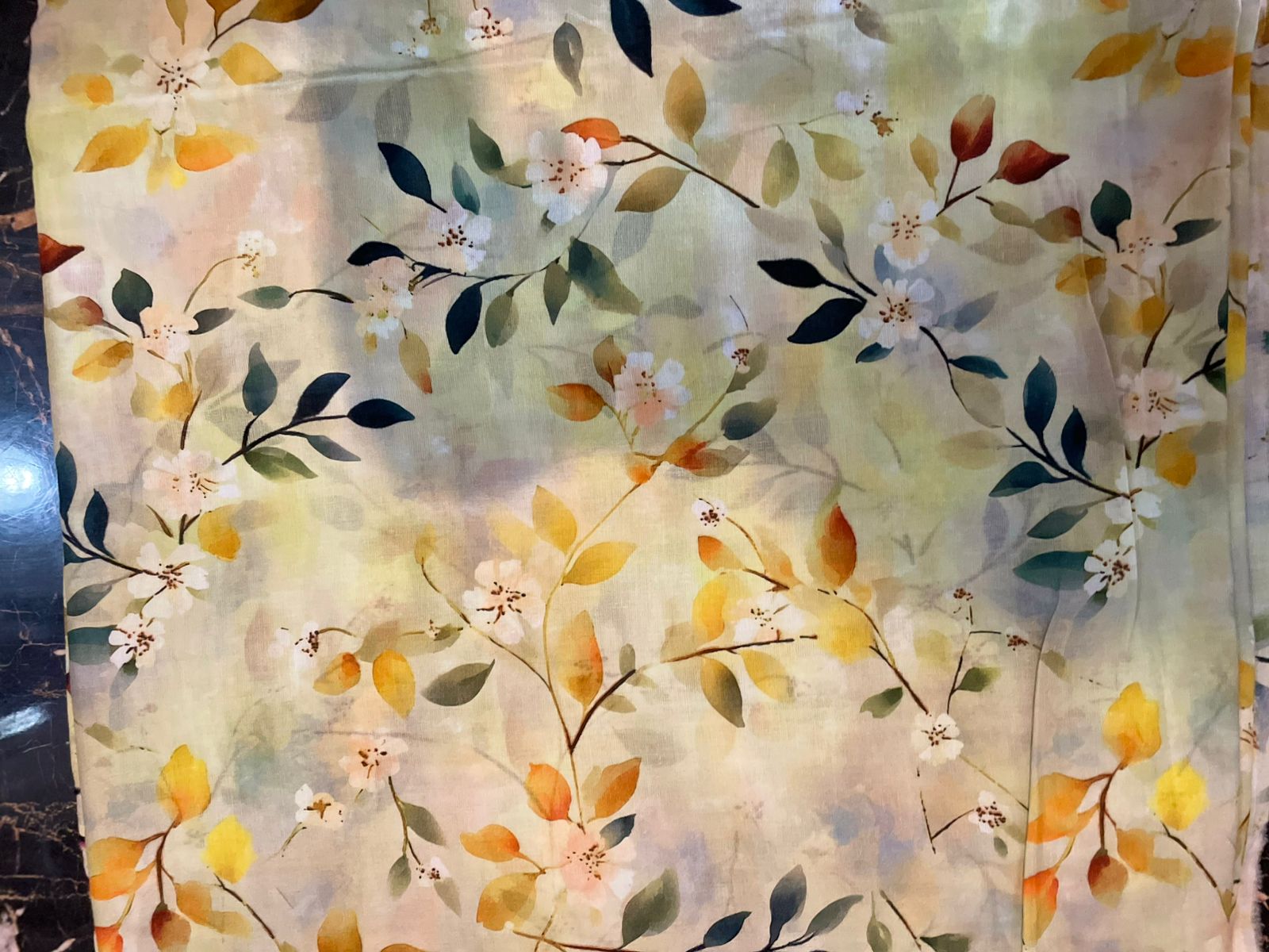 Floral patterned fabric with yellow, green, and orange colors