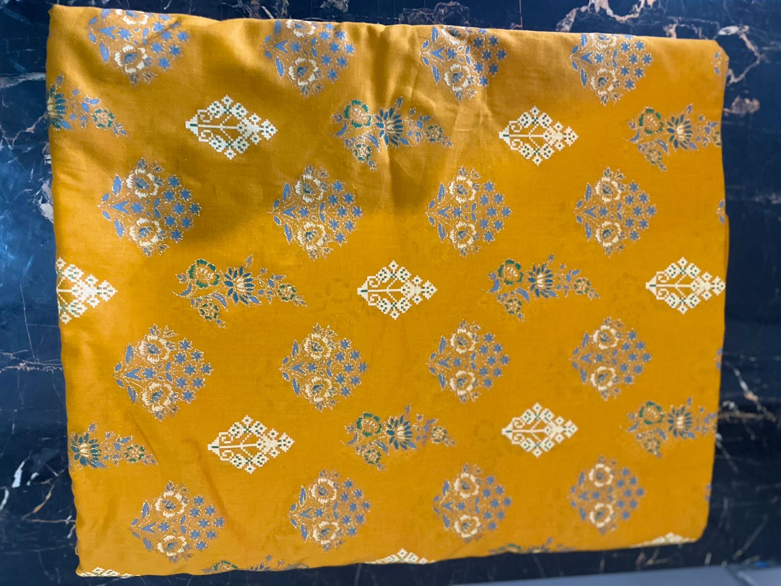 Yellow fabric with gold and white floral patterns