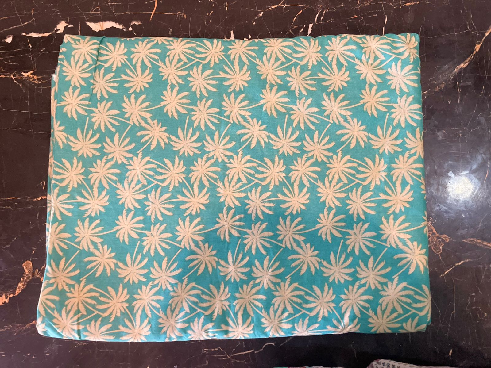 Teal fabric with beige floral pattern 